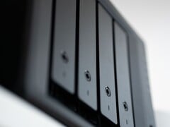 Gros plan sur un boîtier NAS noir comportant plusieurs baies de disques