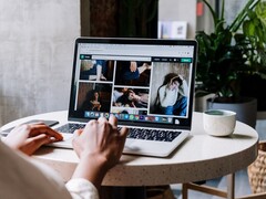 Personne tapant sur un ordinateur portable dans un café, avec à l'écran une fenêtre de navigateur comportant une barre d'onglets et une barre d'adresse