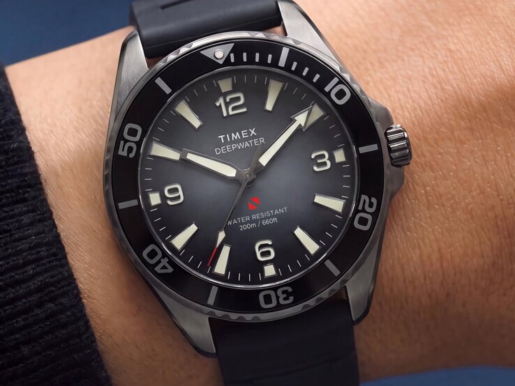 Montre de plongée Timex Deepwater Arctic 200 avec cadran dégradé fumé, lunette en céramique noire, index lumineux et bracelet en caoutchouc noir, portée au poignet.