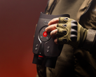 Le DVX Night Storm X3, photographié dans les mains d'une personne portant des gants et un équipement d'extérieur sur fond rouge. (Source de l'image : DVX)