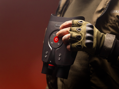 Le DVX Night Storm X3, photographié dans les mains d'une personne portant des gants et un équipement d'extérieur sur fond rouge. (Source de l'image : DVX)