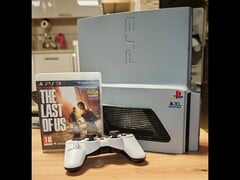 Une "PS3 Slim Pro" personnalisée avec le logo du 30e anniversaire à côté d'une manette DualShock 3 et d'un boîtier The Last of Us. (Source de l'image : Fun-Equivalent-7785 via Reddit / r/PS3)