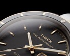 Gros plan sur la Timex Waterbury Heritage Automatic à cadran noir, mettant en valeur ses aiguilles luminescentes facettées, ses index, l’affichage du jour et de la date, ainsi que sa lunette noire.