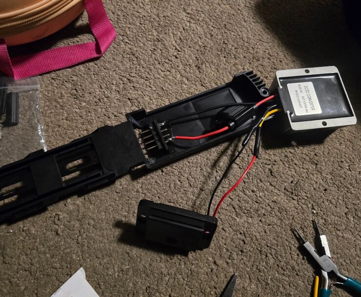 Une installation personnalisée DIY montrant le câblage interne et un convertisseur DC-DC connecté à un adaptateur de batterie eBike, créé pour alimenter en toute sécurité un appareil portable ASUS ROG Ally X. (Source de l'image : DoggoLord27 via r/ROGAlly)