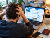 Personne assise devant un ordinateur portable rencontrant des difficultés pour réserver un voyage