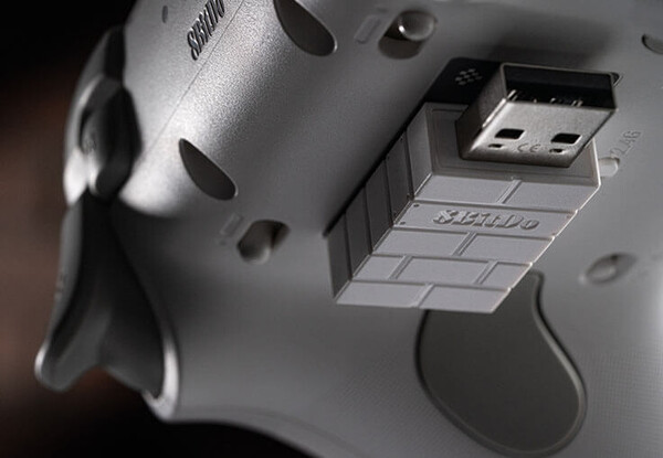 L’adaptateur 2.4GHz se fixe magnétiquement sous la manette sans fil Ultimate 3C+.