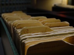 Une rangée de vieux classeurs à anneaux dans une pièce faiblement éclairée.