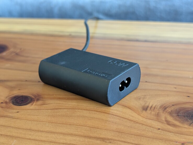Adaptateur secteur USB-C de 65 W fourni avec le Lenovo ThinkPad X1 2-en-1 de 11e génération. Veuillez noter qu'il nécessite un deuxième câble d'alimentation pour se brancher sur une prise, tandis que le câble USB-C est intégré à l'autre extrémité.