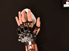 Un exosquelette bricolé attaché à une main lors de l'utilisation d'une souris de jeu (Image source : Basically Homeless/YouTube)