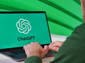 Un homme tape sur un ordinateur portable dont l'écran affiche le logo ChatGPT