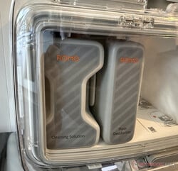 Les deux bidons de détergent derrière le plexiglas