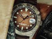 Montre de plongée Huckberry x Timex Deepwater Reef 200 avec cadran marron, boîtier en acier inoxydable, lunette noire et bracelet marron assorti.