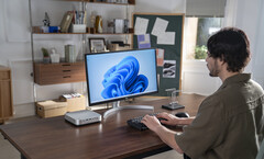 Minisforum a rafraîchi son mini-PC AI X1 Pro, photographié à côté d'un moniteur et d'un clavier sur un bureau, avec du nouveau matériel AMD (source d'image : Minisforum)