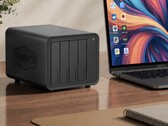 La photo montre le NAS Terramaster D8 Hybrid 2 à côté d'un ordinateur portable posé sur un bureau en bois 