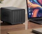 La photo montre le NAS Terramaster D8 Hybrid 2 à côté d'un ordinateur portable posé sur un bureau en bois