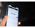 Photo d'une main tenant un smartphone avec la page d'accueil de Google Search ouverte à l'écran. (Source de l'image : Solen Feyissa sur Flickr)