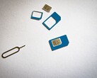 Des cartes SIM de trois tailles différentes et une broche d'éjection sur une surface blanche
