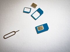Des cartes SIM de trois tailles différentes et une broche d'éjection sur une surface blanche