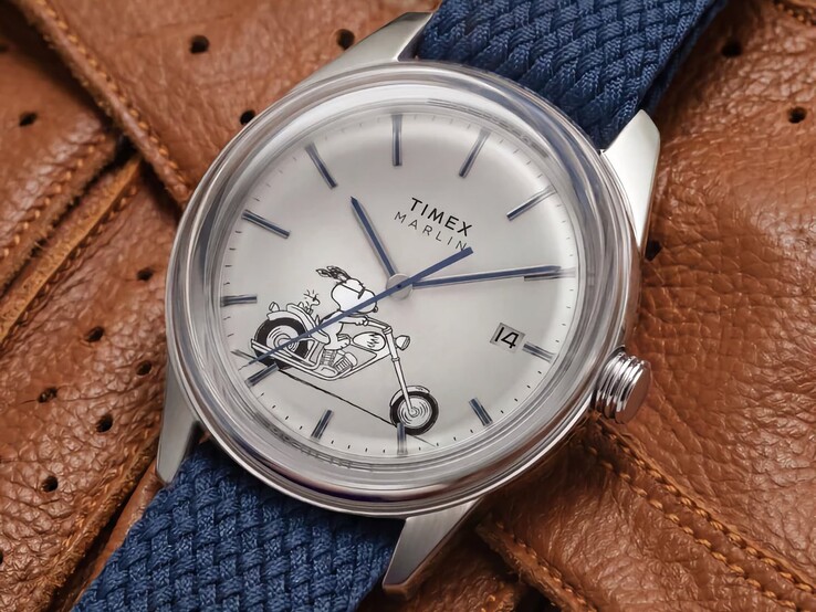 Vue de face en angle de la montre Peanuts x Timex Marlin Jet Automatic Easy Rider, mettant en valeur le verre bombé, le boîtier en acier inoxydable argenté, le cadran sur le thème de Snoopy et le bracelet en tissu bleu.