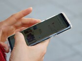 Une main tient un smartphone Android sur lequel s'affiche une application de cartographie.