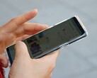 Une main tient un smartphone Android sur lequel s'affiche une application de cartographie.