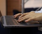 Des mains tapant sur le clavier d'un ordinateur portable sombre