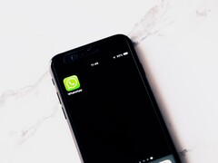 Un smartphone posé sur une table blanche, affichant l’application WhatsApp