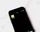 Un smartphone posé sur une table blanche, affichant l’application WhatsApp