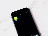 Un smartphone posé sur une table blanche, affichant l’application WhatsApp