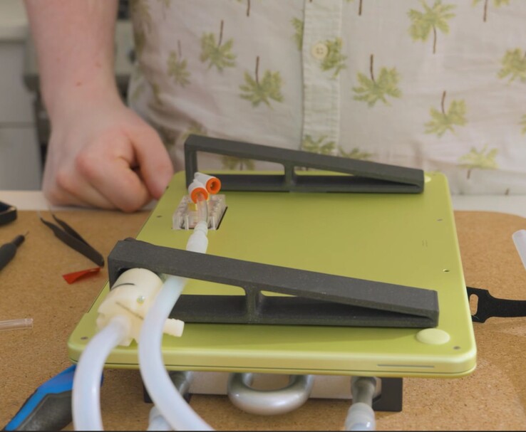 MacBook Neo modifié avec pompe externe et tubulure pour le refroidissement liquide DIY