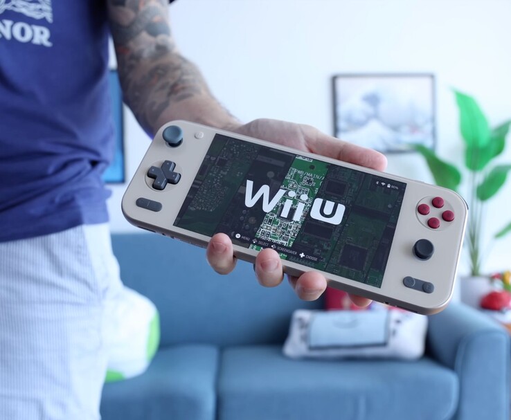 Russ de Retro Game Corps tenant la console portable Ayaneo Pocket S2 avec un émulateur Wii U, l'appareil étant mis en évidence dans un salon. (Source de l'image : Retro Game Corps)