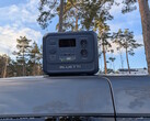 Bluetti Elite 100 V2 à base biologique sur le toit d'une voiture avec des pins en arrière-plan