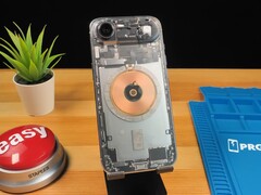 IPhone Air transparent montrant les composants internes et la bobine de charge en cuivre sur un bureau en bois (Source de l&#039;image : Phone Repair Guru via YouTube)