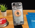 IPhone Air transparent montrant les composants internes et la bobine de charge en cuivre sur un bureau en bois (Source de l'image : Phone Repair Guru via YouTube)