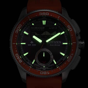 Prise de vue de la Citizen Promaster Wave Tracker JV3000-13E en basse lumière, montrant les aiguilles et les index lumineux sur fond sombre.