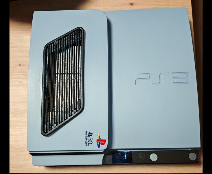 Vue du dessus de la PS3 Slim Pro gris argent mat personnalisée avec des accents noirs, avec une grille d'aération et un logo PlayStation 30e anniversaire sur le boîtier. (Source de l'image : Fun-Equivalent-7785 via Reddit / r/PS3)