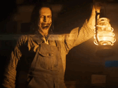 Une figure sinistre tenant une lanterne laisse présager les horreurs à venir dans la série The Conjuring (Image source : Warner Bros)