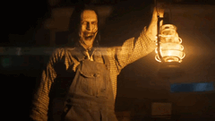 Une figure sinistre tenant une lanterne laisse présager les horreurs à venir dans la série The Conjuring (Image source : Warner Bros)