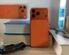 Apple iPhone 17 Air en finition orange montrant le design de l'arrière et le module caméra placé sur des livres empilés