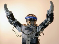 Un robot humanoïde avec les bras en l&#039;air (Source de l&#039;image : Adam Lukomski via Unsplash ; recadré)