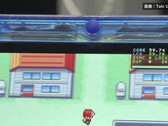Gros plan de la console portable FPGBA SP bleu transparent faisant tourner Pokémon, avec un compteur affichant 59.74 FPS.