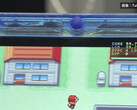 Gros plan de la console portable FPGBA SP bleu transparent faisant tourner Pokémon, avec un compteur affichant 59.74 FPS.