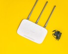 Routeur Wi-Fi blanc doté de trois antennes et d'un bloc d'alimentation, sur fond jaune