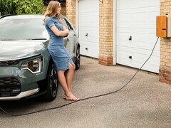 Une dame qui attend qu'un véhicule électrique soit rechargé