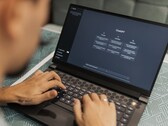 Une personne tape sur un ordinateur portable, l'interface ChatGPT étant ouverte