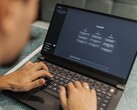 Une personne tape sur un ordinateur portable, l'interface ChatGPT étant ouverte