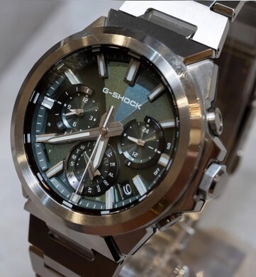 Gros plan sur la Casio G-Shock GST-W1000D-3A à cadran vert, montrant son cadran à texture géométrique, ses trois sous-cadrans, ses index luminescents et sa lunette en acier inoxydable poli.