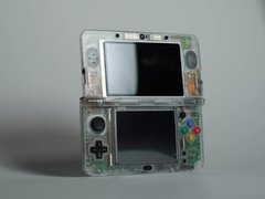 Une Nintendo 3DS avec une coque de palourde transparente personnalisée