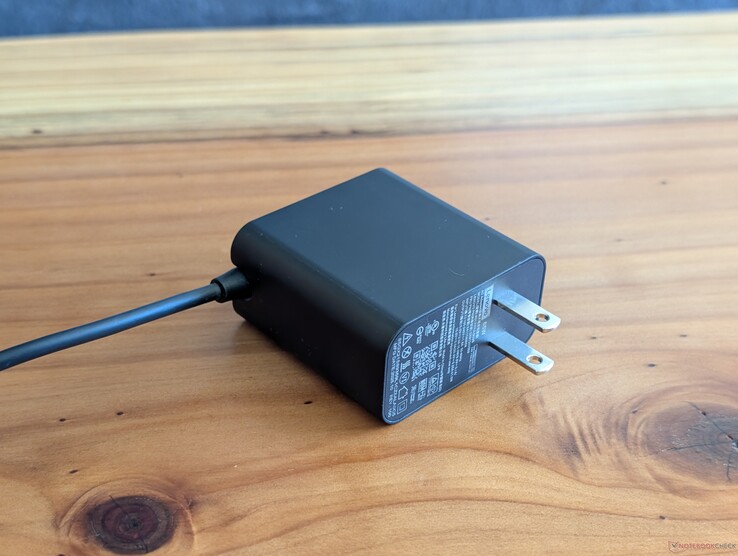 Adaptateur secteur USB-C de 65 W fourni avec le Lenovo Yoga Slim 7 14. Veuillez noter que les broches secteur ne sont pas rétractables et que l'autre extrémité est équipée d'un câble USB-C intégré.
