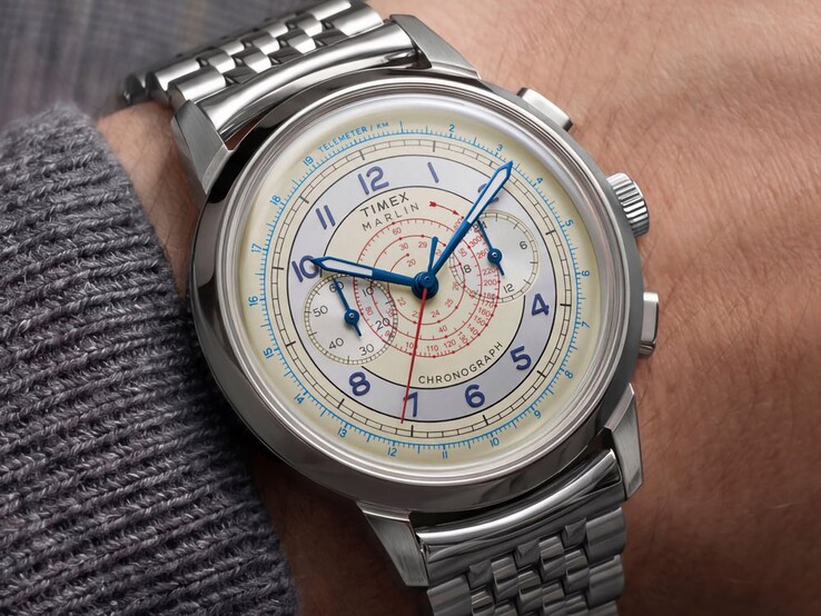 Chronographe Timex Marlin Neo Classic doté d’un cadran crème, d’aiguilles bleues et d’un bracelet en acier inoxydable, porté au poignet.